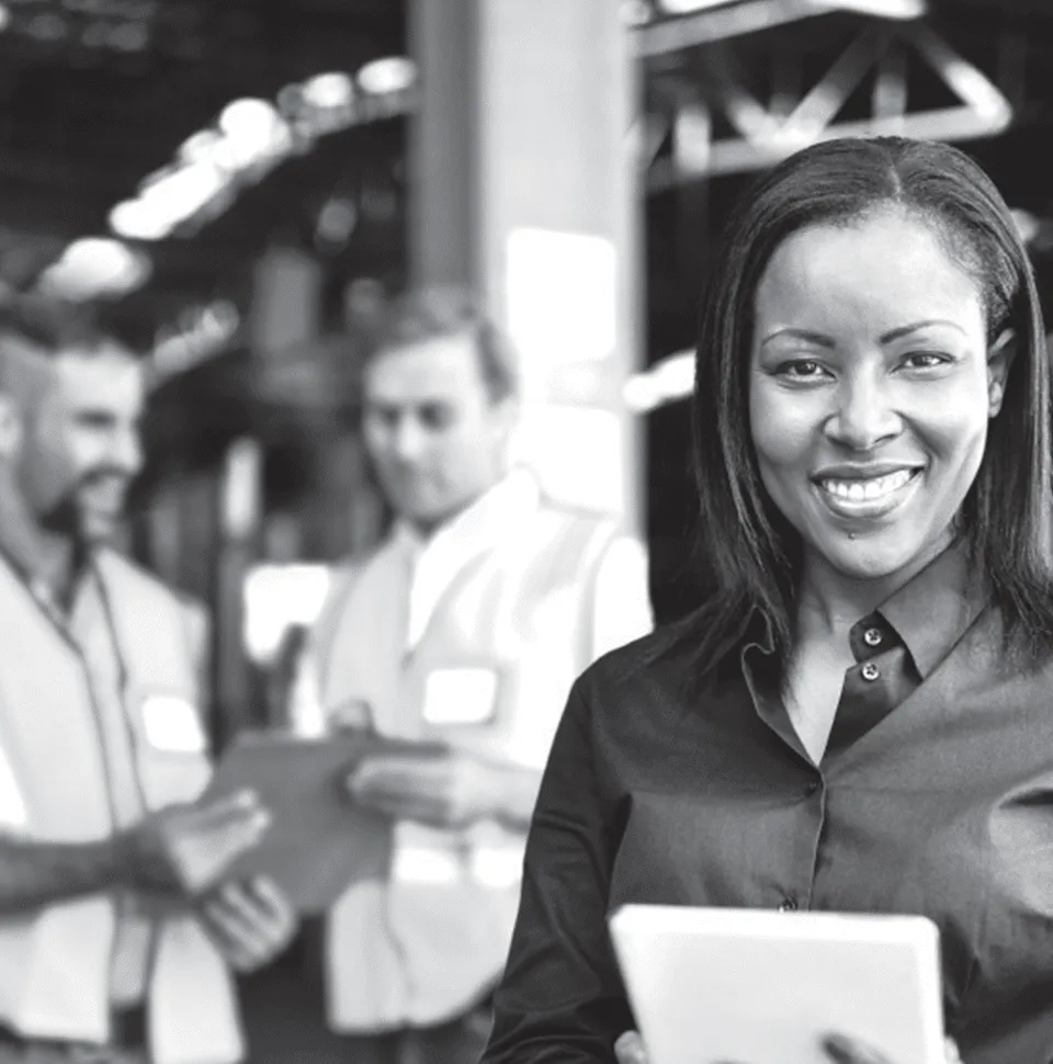 Integrity Core Value 960x970 Business woman smiling standing in front of two male workers looking at a clipboard